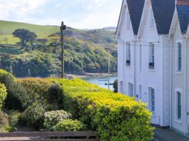 A view of a house with bushes and water at 4 The Elms Salcombe