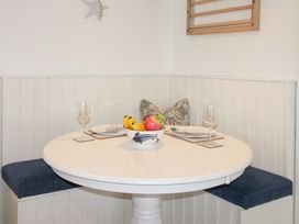 A dining area with a round table and fruit bowl at 4 The Elms in Salcombe