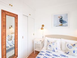 A bedroom with a bed and a mirror at 4 The Elms in Salcombe