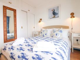 A bedroom with a bed and a mirror at 4 The Elms Salcombe