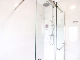 A shower with glass door and tiled wall at 4 The Elms Salcombe