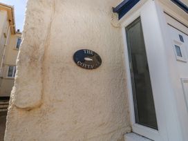 A nameplate on the wall next to a door at The Cottage in Budleigh Salterton