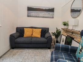 A snug with a gray sofa and yellow cushions at The Cottage Budleigh Salterton