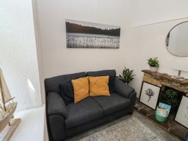 A living room with a sofa and wall art at The Cottage in Budleigh Salterton