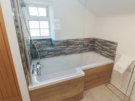 A bathroom with a bathtub and a towel rack at The Cottage Budleigh Salterton