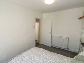 A bedroom with a bed and door leading to another room at The Cottage in Budleigh Salterton