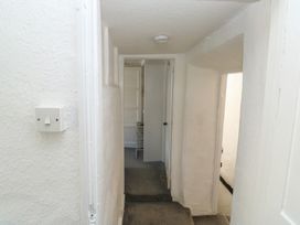 A hallway with a light switch and doors at The Cottage in Budleigh Salterton