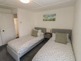 A bedroom with two single beds and bedside table at The Cottage in Budleigh Salterton