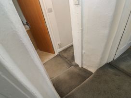 A hallway with carpet and doors leading to other rooms at The Cottage in Budleigh Salterton