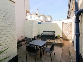 An outdoor area with a table and chairs at The Cottage in Budleigh Salterton