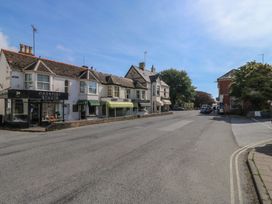 A street view with shops and vehicles at The Cottage in Budleigh Salterton