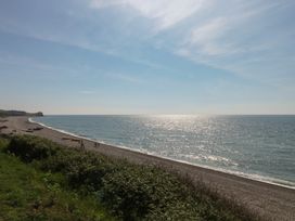 A beach with pebbles and people walking at The Cottage Budleigh Salterton