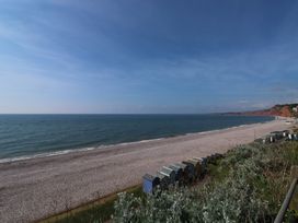 A beach with pebbles and beach huts at The Cottage in Budleigh Salterton