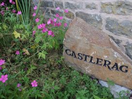 A stone with the name Castlerag surrounded by flowers at Castlerag in Parkend