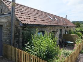 A stone building with a roof and outdoor seating at Castle Rag in Parkend