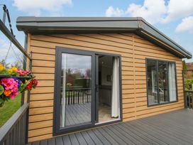 An exterior view of a house with a deck and large windows at Tulip in Eardisland