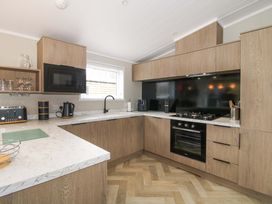 A kitchen with wooden cabinets and appliances at Tulip in Eardisland