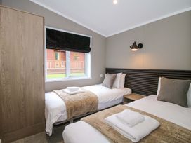 A bedroom with two beds and a wardrobe at Tulip in Eardisland