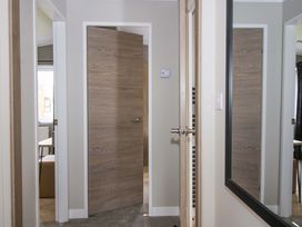 A corridor with a door and mirror at Tulip in Eardisland