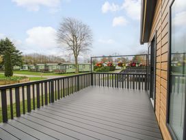 A deck with flowers in pots and caravans at Tulip in Eardisland