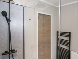 A bathroom with a shower, toilet, and towel radiator at Poppy in Eardisland