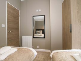 A bedroom with a bed and wardrobe at Poppy in Eardisland