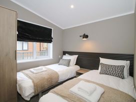 A bedroom with two beds and a window at Poppy in Eardisland