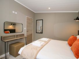 A bedroom with a bed and desk at Poppy in Eardisland