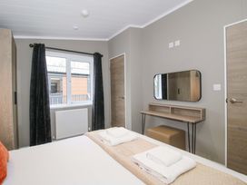 A bedroom with a bed and desk at Poppy Eardisland