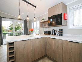 A kitchen with appliances and a window at Poppy in Eardisland