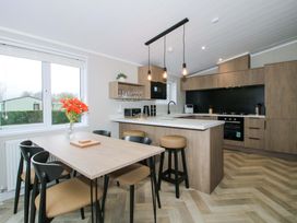 A kitchen with dining table and stools at Poppy in Eardisland