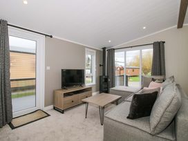 A living room with a television and a coffee table at Poppy in Eardisland