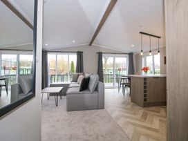 A living room with a sofa and dining area at Poppy Eardisland