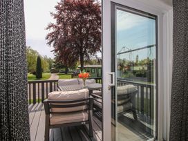 A deck with outdoor furniture overlooking a garden at Poppy in Eardisland