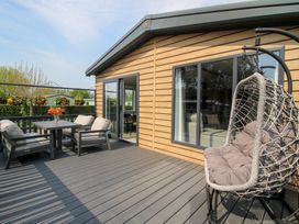 An outdoor patio with a table and chairs at Poppy Eardisland