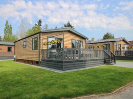 A cabin with a deck and flower pots at Poppy in Eardisland