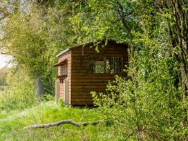 A wooden shed surrounded by trees at Poppy in Eardisland