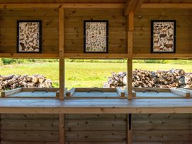 A wooden counter with framed artwork and a view of logs at Poppy in Eardisland