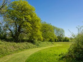A pathway through trees and grass at Poppy in Eardisland