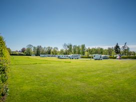 A caravan site with several caravans on grass at Poppy in Eardisland