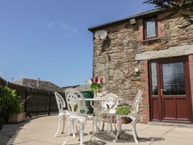 An outdoor patio with a table and chairs at Applestore in Wadebridge