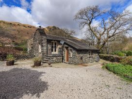 A house surrounded by mountains and trees at Beckside Studio Penrith