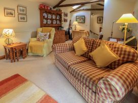 A living room with a plaid sofa and shelves at Beckside Studio Penrith