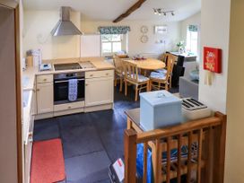 A kitchen with an oven and dining table at Beckside Studio in Penrith