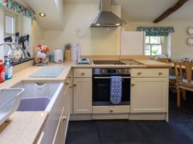A kitchen with an oven, sink, and dining table at Beckside Studio in Penrith