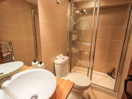 A bathroom with a shower, sink, and toilet at Beckside Studio in Penrith