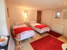 A bedroom with two beds and a lamp at Beckside Studio in Penrith