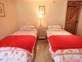 A bedroom with two beds and a bedside table at Beckside Studio in Penrith