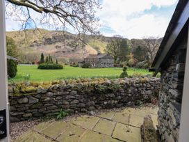 A garden with a stone wall and mountains in the background at Beckside Studio in Penrith