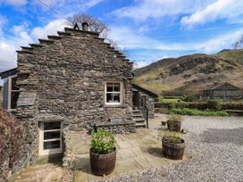 An outdoor area with a stone wall and planters at Beckside Studio in Penrith